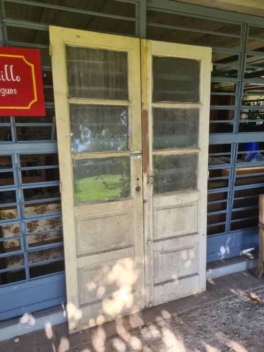 Puerta doble de madera cancharana con 3 vidrios por hoja, 2,10 m de alto.